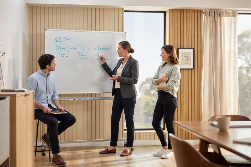 A spacious modern office floor at dusk with a glass meeting room and city view