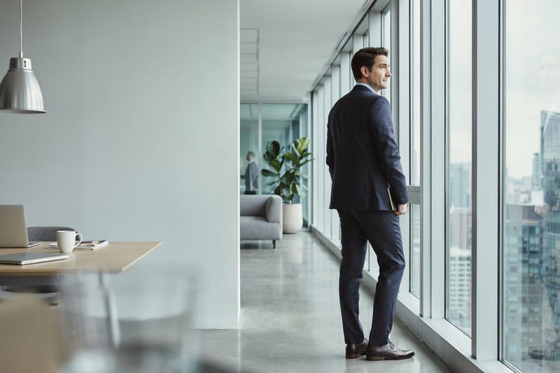 A technology leader looking out over the city from an office window